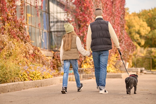 Una familia paseando con un perro.