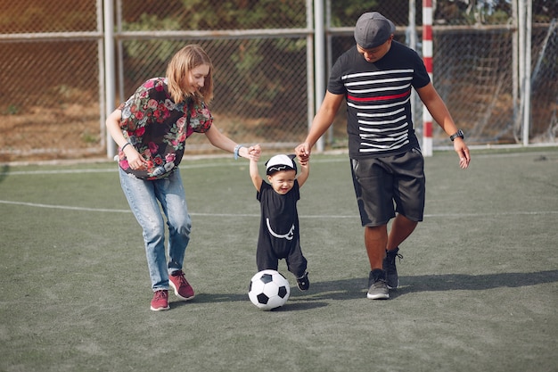 Familia con pequeño hijo jugando al fútbol