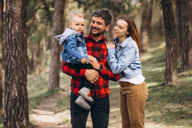 Familia con pequeño hijo juntos en el bosque