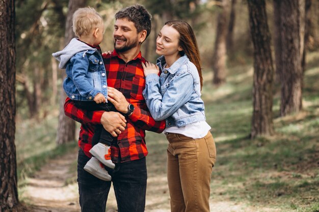 Familia con pequeño hijo juntos en el bosque