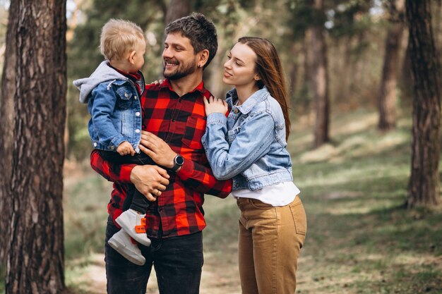 Familia con pequeño hijo juntos en el bosque