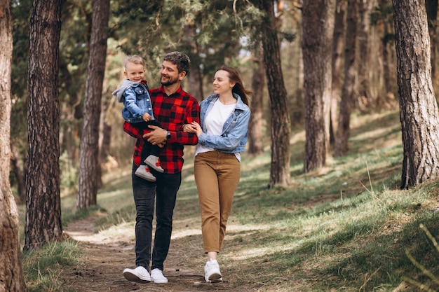 Familia con pequeño hijo juntos en el bosque