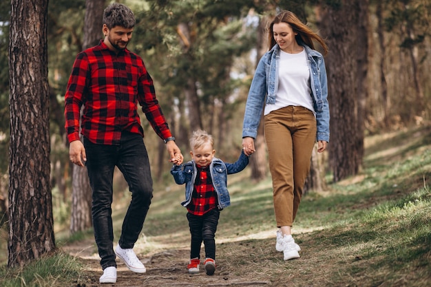 Familia con pequeño hijo juntos en el bosque