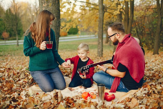 Familia con pequeño hijo en un parque de otoño