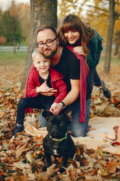 Familia con pequeño hijo en un parque de otoño