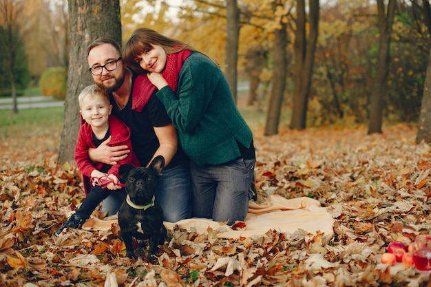 Familia con pequeño hijo en un parque de otoño