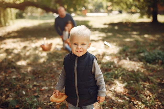 Familia con pequeño hijo en un parque de otoño