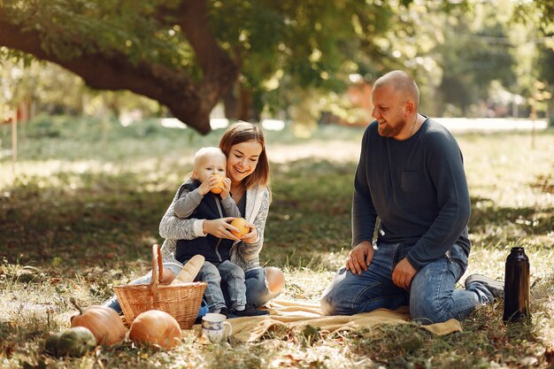 Familia con pequeño hijo en un parque de otoño