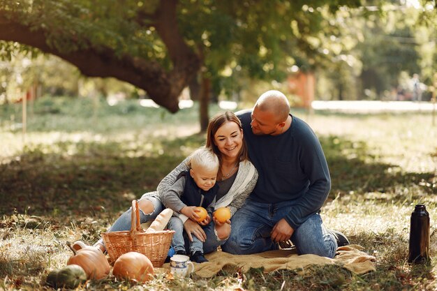 Familia con pequeño hijo en un parque de otoño