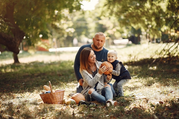 Familia con pequeño hijo en un parque de otoño