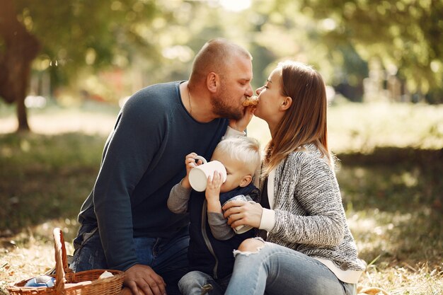 Familia con pequeño hijo en un parque de otoño