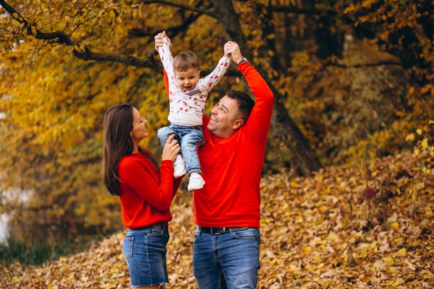 Familia con un pequeño hijo en el parque otoño