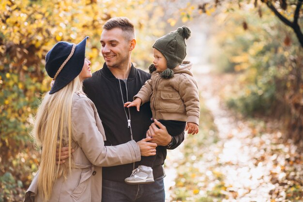 Familia con un pequeño hijo en el parque otoño