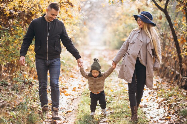 Familia con un pequeño hijo en el parque otoño