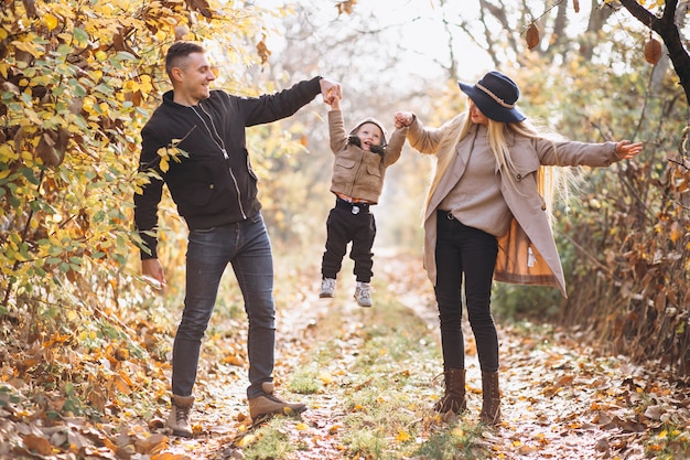 Familia con un pequeño hijo en el parque otoño