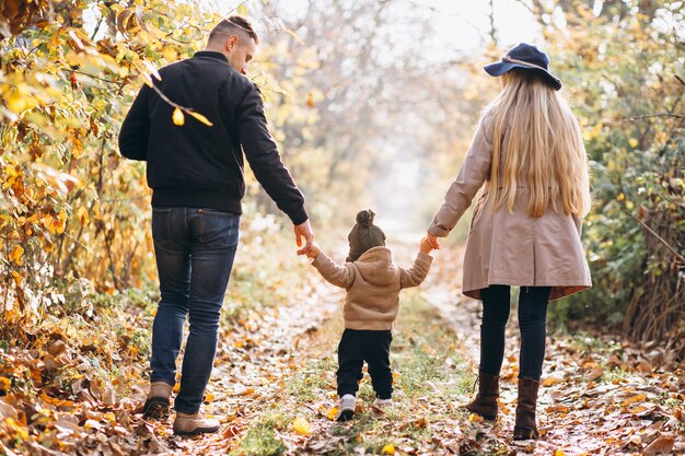 Familia con un pequeño hijo en el parque otoño