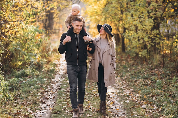 Familia con un pequeño hijo en el parque otoño