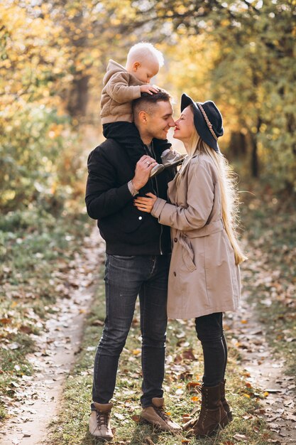 Familia con un pequeño hijo en el parque otoño