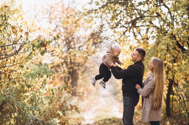 Familia con un pequeño hijo en el parque otoño