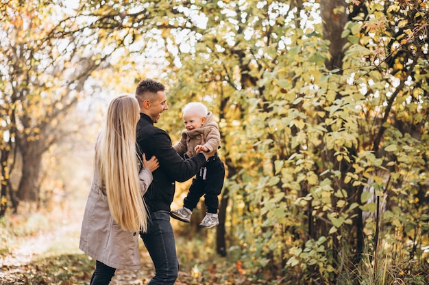 Familia con un pequeño hijo en el parque otoño