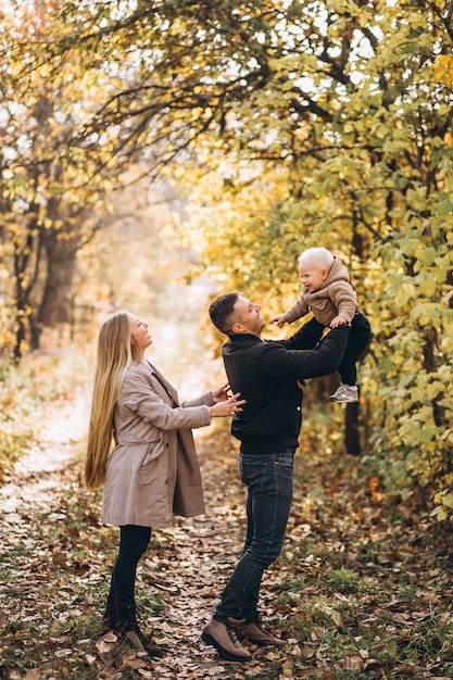 Familia con un pequeño hijo en el parque otoño