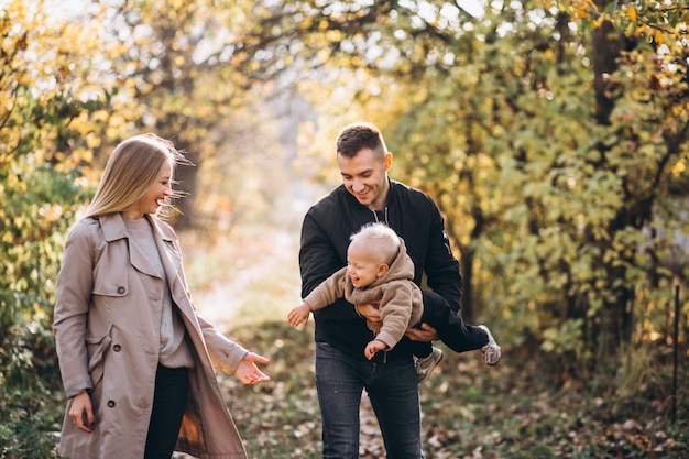 Familia con un pequeño hijo en el parque otoño