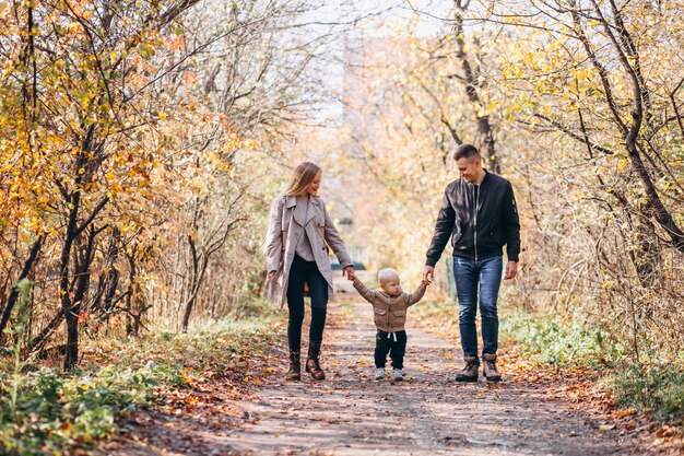 Familia con un pequeño hijo en el parque otoño