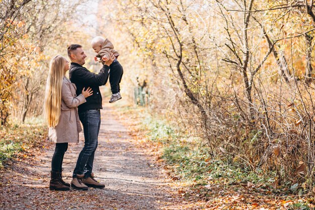 Familia con un pequeño hijo en el parque otoño