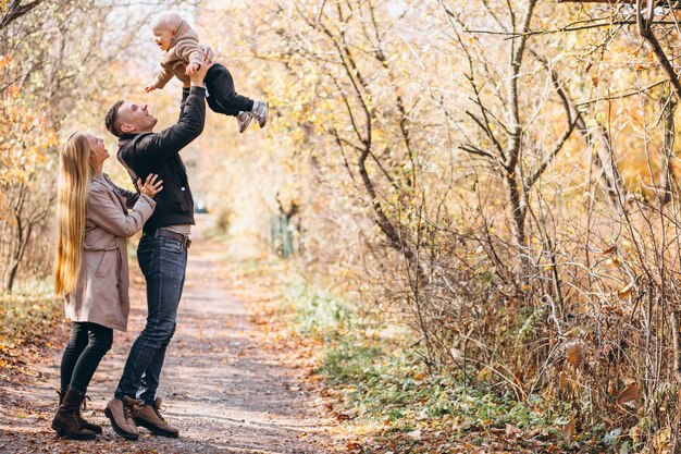 Familia con un pequeño hijo en el parque otoño