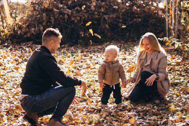 Familia con un pequeño hijo en el parque otoño