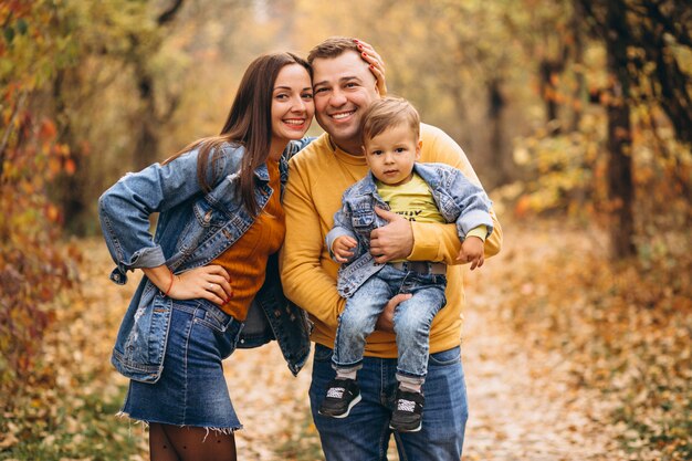 Familia con un pequeño hijo en el parque otoño