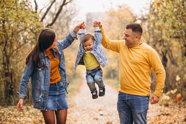 Familia con un pequeño hijo en el parque otoño