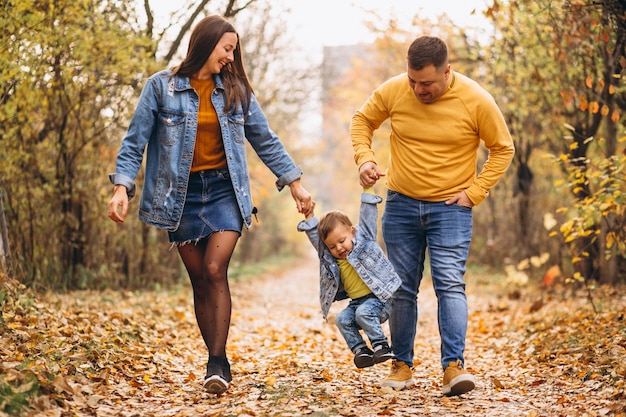 Familia con un pequeño hijo en el parque otoño