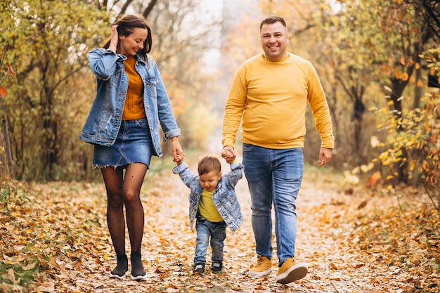 Familia con un pequeño hijo en el parque otoño