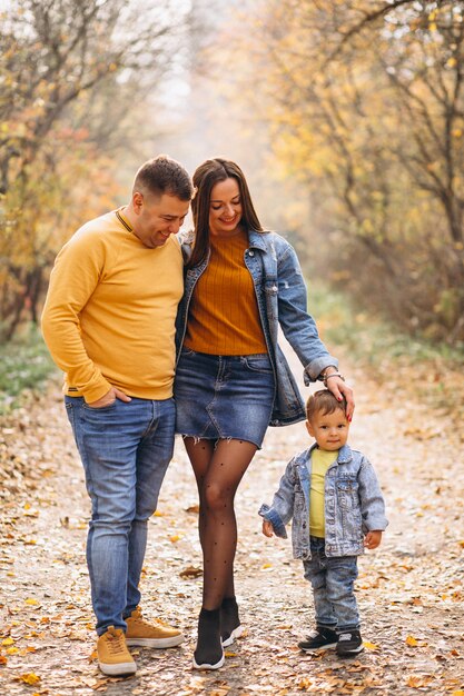 Familia con un pequeño hijo en el parque otoño