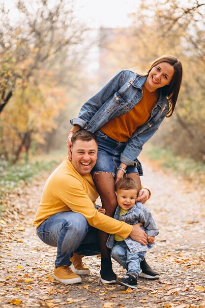 Familia con un pequeño hijo en el parque otoño