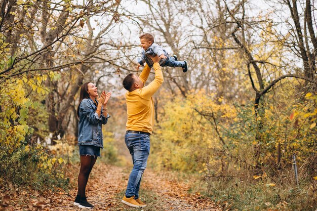 Familia con un pequeño hijo en el parque otoño