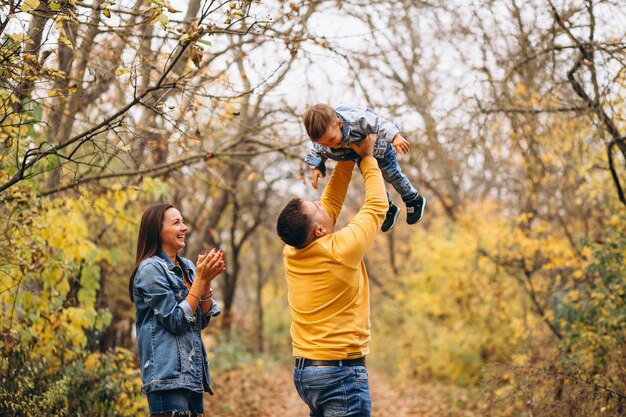 Familia con un pequeño hijo en el parque otoño