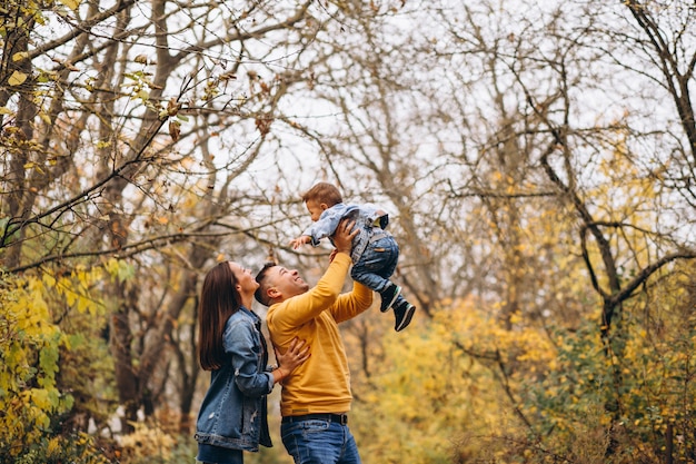 Familia con un pequeño hijo en el parque otoño
