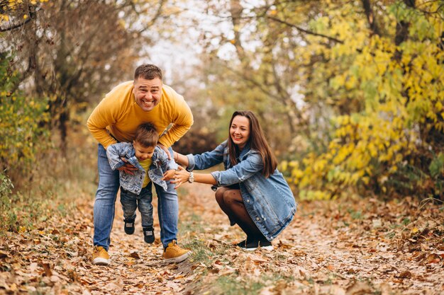 Familia con un pequeño hijo en el parque otoño