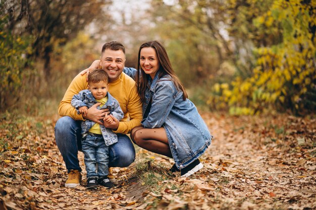 Familia con un pequeño hijo en el parque otoño