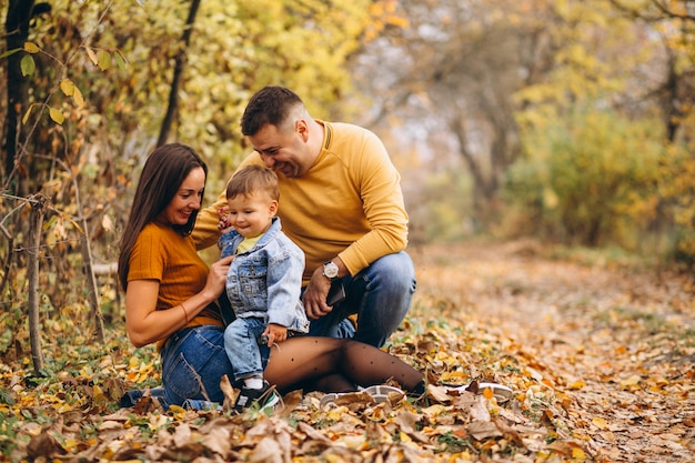 Familia con un pequeño hijo en el parque otoño