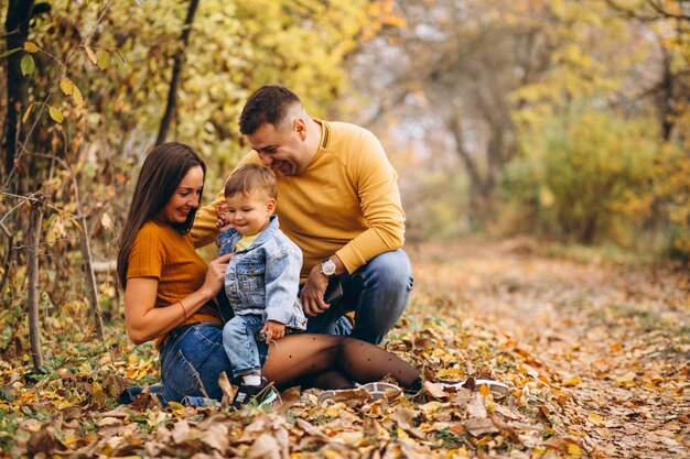 Familia con un pequeño hijo en el parque otoño