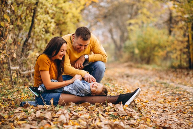 Familia con un pequeño hijo en el parque otoño