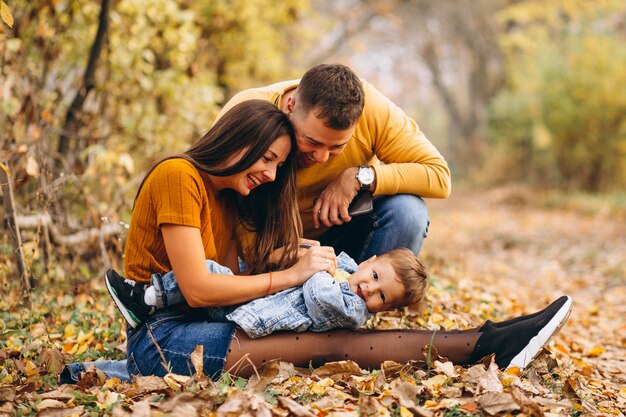 Familia con un pequeño hijo en el parque otoño