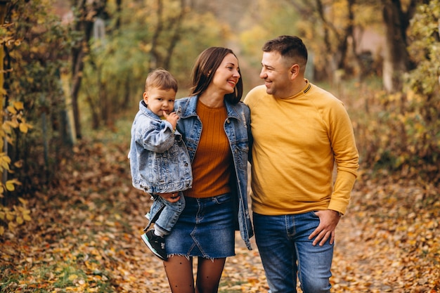 Familia con un pequeño hijo en el parque otoño