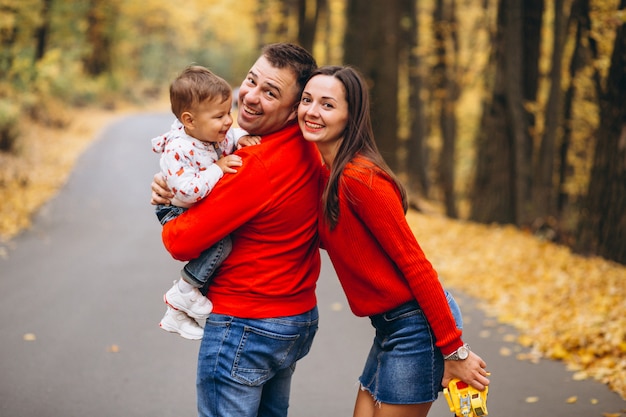 Familia con un pequeño hijo en el parque otoño