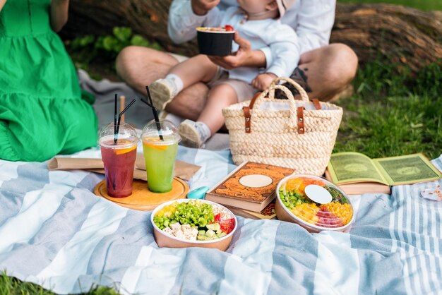 Familia en un picnic con poke en el parque