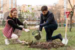 Foto gratuita familia plateando juntos un árbol