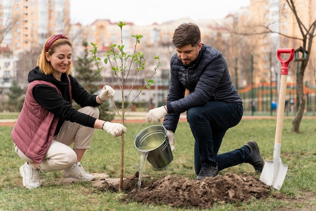 Familia plateando juntos un árbol